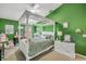 Bright bedroom with green walls, canopy bed, carpet, and white furniture at 116 Douglas St, Edgewater, FL 32141