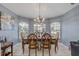 Bright dining room features tile floors and a chandelier over the wood table with six decorative chairs at 116 Douglas St, Edgewater, FL 32141