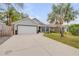 Well-maintained single-Gathering home featuring a two-car garage and a tidy front yard with a palm tree at 116 Douglas St, Edgewater, FL 32141