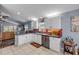 Well-lit kitchen boasts white cabinets, gray countertops, and a red backsplash, adjacent to a cozy living space at 116 Douglas St, Edgewater, FL 32141