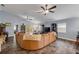 Open living room with vaulted ceiling, ceiling fans, wood-look flooring, leather sectional, and access to the backyard at 116 Douglas St, Edgewater, FL 32141