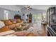 Comfortable living room with vaulted ceiling, wood-look floors, leather sectional, and sliding glass doors to the patio at 116 Douglas St, Edgewater, FL 32141