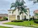 Two-story home with lush landscaping, tile roof, and a paver driveway at 12059 Uleta Ln, Orlando, FL 32827