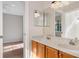 Bathroom featuring double sinks with wood cabinets, a mirror, and access to the bedroom at 1330 Shelter Rock Rd, Orlando, FL 32835