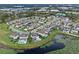 Aerial shot of lakeside homes featuring pools and solar panels, amidst lush greenery at 1380 Patterson Ter, Lake Mary, FL 32746