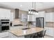 Modern kitchen featuring white cabinets, stainless steel appliances, and a granite-topped island at 1380 Patterson Ter, Lake Mary, FL 32746