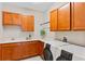 Well-equipped laundry room with wooden cabinets, sink, and modern washer/dryer at 1380 Patterson Ter, Lake Mary, FL 32746