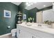 Bathroom featuring a double sink vanity, dark green walls and modern finishes at 15373 Murcott Harvest Loop, Winter Garden, FL 34787