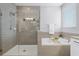 Modern bathroom with a glass-enclosed shower, a soaking tub and neutral toned tiles at 15373 Murcott Harvest Loop, Winter Garden, FL 34787