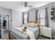 Light-filled bedroom with a ceiling fan, wood-frame bed, and neutral-toned decor at 15373 Murcott Harvest Loop, Winter Garden, FL 34787