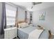 Bright bedroom with a wood-frame bed, soft blue bedding, and plenty of natural light from the windows at 15373 Murcott Harvest Loop, Winter Garden, FL 34787