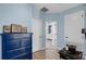 Bright bedroom with blue walls, a dark blue dresser, and natural light from the doorway at 15373 Murcott Harvest Loop, Winter Garden, FL 34787