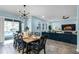 Bright dining area featuring a wood table, black chairs, and a modern chandelier, open to the living room at 15373 Murcott Harvest Loop, Winter Garden, FL 34787