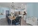Charming dining area with wood table, black chairs, and white kitchen in the background at 15373 Murcott Harvest Loop, Winter Garden, FL 34787
