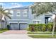 Two-story home featuring a two-car garage, solar panels, well-maintained landscaping, and a charming blue facade at 15373 Murcott Harvest Loop, Winter Garden, FL 34787