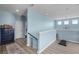 Second story hallway with blue walls and luxury vinyl plank flooring at 15373 Murcott Harvest Loop, Winter Garden, FL 34787