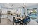Open-concept kitchen and dining area with white cabinets, stainless steel appliances, and a view of the pool at 15373 Murcott Harvest Loop, Winter Garden, FL 34787