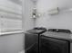Laundry room featuring modern washer and dryer units, as well as a storage shelf at 15373 Murcott Harvest Loop, Winter Garden, FL 34787