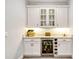 Elegant bar area featuring white cabinetry, granite countertops, and a beverage cooler at 1905 Estuary Ln, Kissimmee, FL 34747