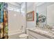 Bright bathroom features a tiled shower, decorative shower curtain, and vanity with granite countertop at 1905 Estuary Ln, Kissimmee, FL 34747