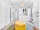 Stylish bonus room with wood floors and a bright chandelier, ample closet storage, and comfortable yellow ottoman at 1905 Estuary Ln, Kissimmee, FL 34747
