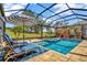 Stunning pool and spa with screened enclosure, lounge chairs and striped umbrella for a luxurious outdoor experience at 1905 Estuary Ln, Kissimmee, FL 34747