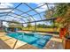 Sparkling pool and integrated spa, surrounded by a screened enclosure and manicured landscaping for outdoor enjoyment and privacy at 1905 Estuary Ln, Kissimmee, FL 34747