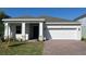 Charming single-story home with a brick driveway and two-car garage, set against a bright blue sky at 2051 Town Pasture Dr, Eustis, FL 32726