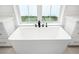 Close-up of a modern white soaking tub featuring black hardware and surrounded by white cabinets at 2248 Middleton Ave, Winter Park, FL 32792