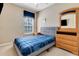 Cozy bedroom with neutral walls, dresser with mirror, and window with blue blind at 2328 Caravelle Cir, Kissimmee, FL 34746