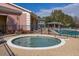 Community hot tub adjacent to a pool with ample lounge seating and lush landscaping at 2328 Caravelle Cir, Kissimmee, FL 34746