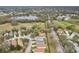 An aerial view of a residential neighborhood with well-maintained homes, greenery, pond and a golf course at 25239 Cranes Roost Cir, Leesburg, FL 34748