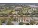 Scenic aerial view of a residential neighborhood with a golf course and lake nearby at 25239 Cranes Roost Cir, Leesburg, FL 34748