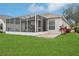 Enclosed screened in patio overlooking a lush yard, offering privacy and relaxation at 25239 Cranes Roost Cir, Leesburg, FL 34748