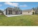 Back of house with enclosed patio and nice lawn at 25239 Cranes Roost Cir, Leesburg, FL 34748