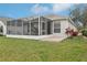 Exterior shot of the home featuring a screened-in lanai and well-maintained lawn at 25239 Cranes Roost Cir, Leesburg, FL 34748