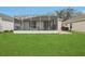 Screened lanai in a well-maintained yard with beautiful plants at 25239 Cranes Roost Cir, Leesburg, FL 34748