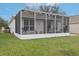 Back of the house featuring a screened-in patio and well-maintained backyard at 25239 Cranes Roost Cir, Leesburg, FL 34748