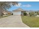 Well-maintained single-story home with a two-car garage and a lush green lawn at 25239 Cranes Roost Cir, Leesburg, FL 34748