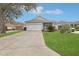 Charming single-story home featuring a well-manicured lawn, and attached two-car garage at 25239 Cranes Roost Cir, Leesburg, FL 34748