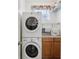 A stacked washer and dryer with upper and lower cabinets in the laundry room makes doing laundry convenient at 25239 Cranes Roost Cir, Leesburg, FL 34748