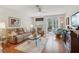 Cozy living room with hardwood floors, comfortable seating, and sliding glass doors to a patio at 25239 Cranes Roost Cir, Leesburg, FL 34748