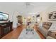 Inviting living room featuring hardwood floors, a fireplace, and an open layout to the dining area at 25239 Cranes Roost Cir, Leesburg, FL 34748