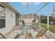 Relaxing screened-in patio featuring comfortable seating and a view of the backyard at 25239 Cranes Roost Cir, Leesburg, FL 34748