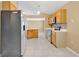Modern kitchen equipped with stainless steel appliances, light wood cabinetry, and durable tile floors for lasting appeal at 3001 Bellingham Dr, Orlando, FL 32825