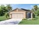 Charming single-story home with a beige stucco finish, complemented by a well-manicured lawn and lush tropical landscaping at 3021 Moulin Rd, Davenport, FL 33837