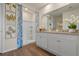 Bright bathroom features a double vanity, neutral-toned countertop, and walk-in shower with decorative accents at 3178 Partington Blvd, Davenport, FL 33837