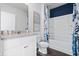 Charming bathroom featuring a white vanity, quartz countertop, white tub/shower and blue floral shower curtain at 3178 Partington Blvd, Davenport, FL 33837