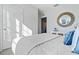 Bright bedroom with a white door, a large mirror, and a comfortable-looking bed with blue pillows at 3178 Partington Blvd, Davenport, FL 33837