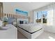 Bright bedroom features a plush bed, stylish decor, and a large window, creating a comfortable and inviting space at 3178 Partington Blvd, Davenport, FL 33837